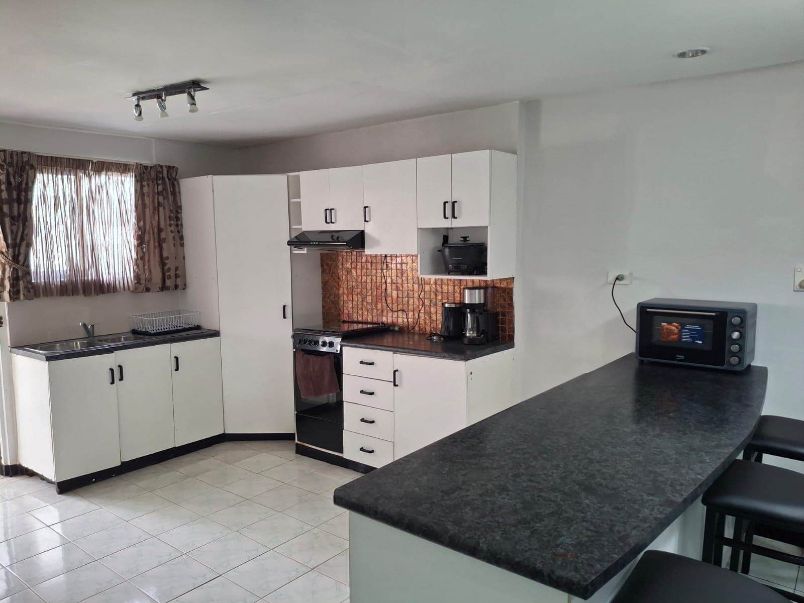 Kitchen with oven, stovetop, microwave and breakfast bar