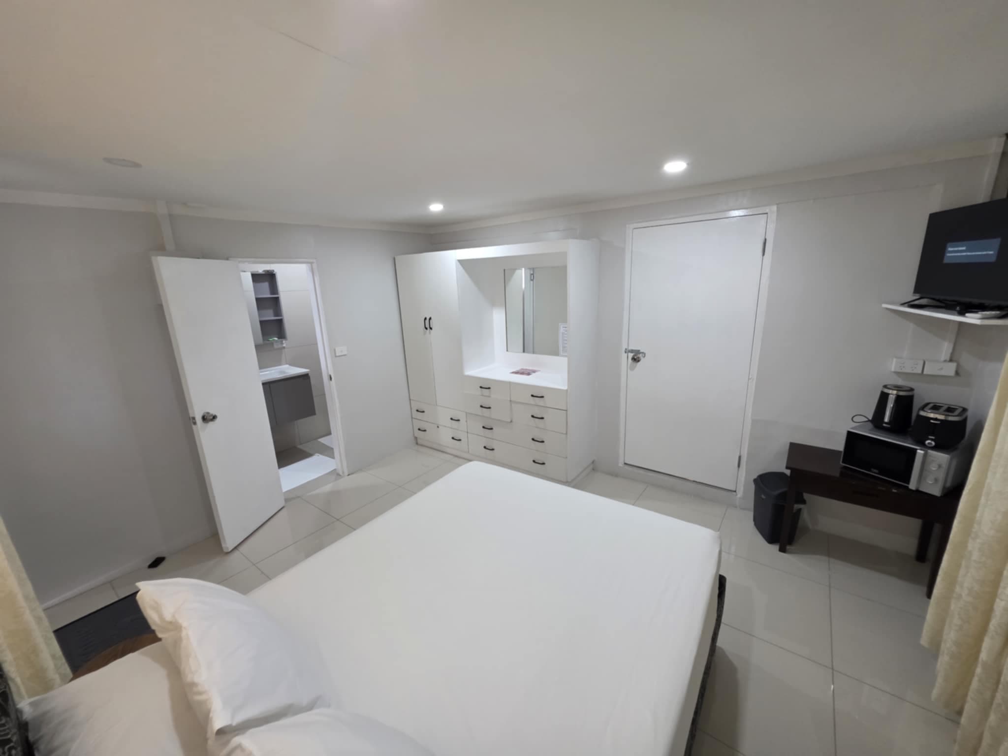 Studio room with a double bed, built-in dresser, TV and tea and coffee station