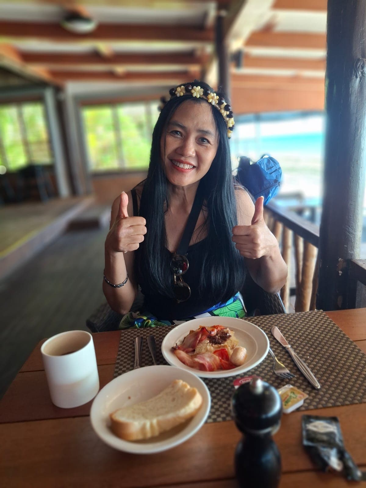 A guest giving two thumbs up over a meal at the resort
