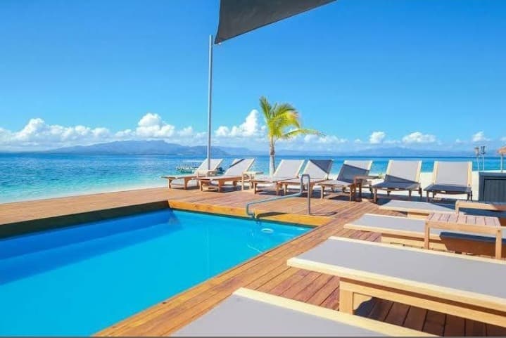 Sun loungers on the pool deck at Serenity Island Resort, looking out over the lagoon.